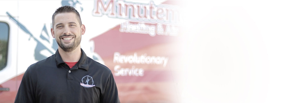 Minuteman technician standing in front of a Minuteman Logo Van in a faded background