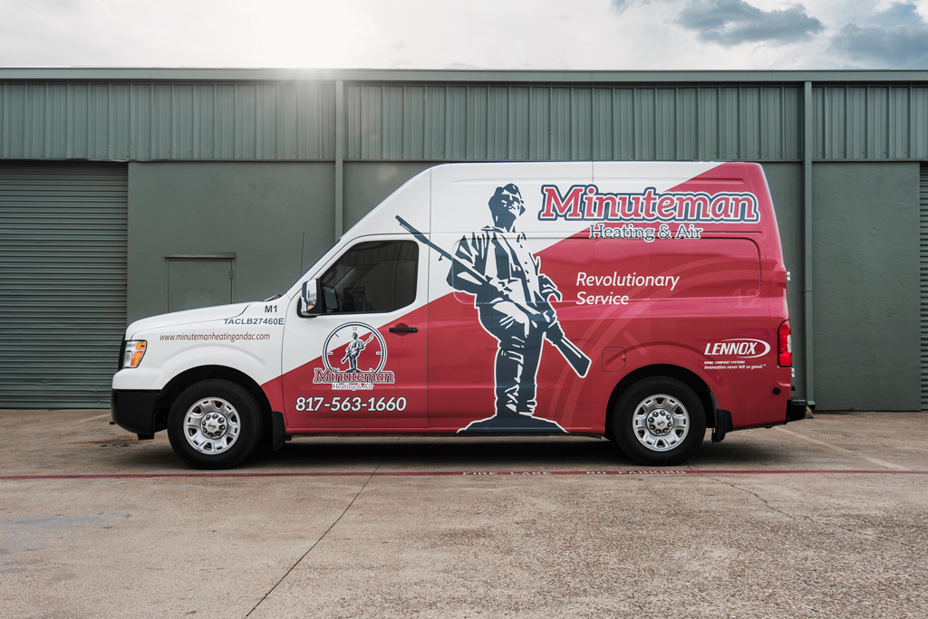 Minuteman logo van parked in front of green building